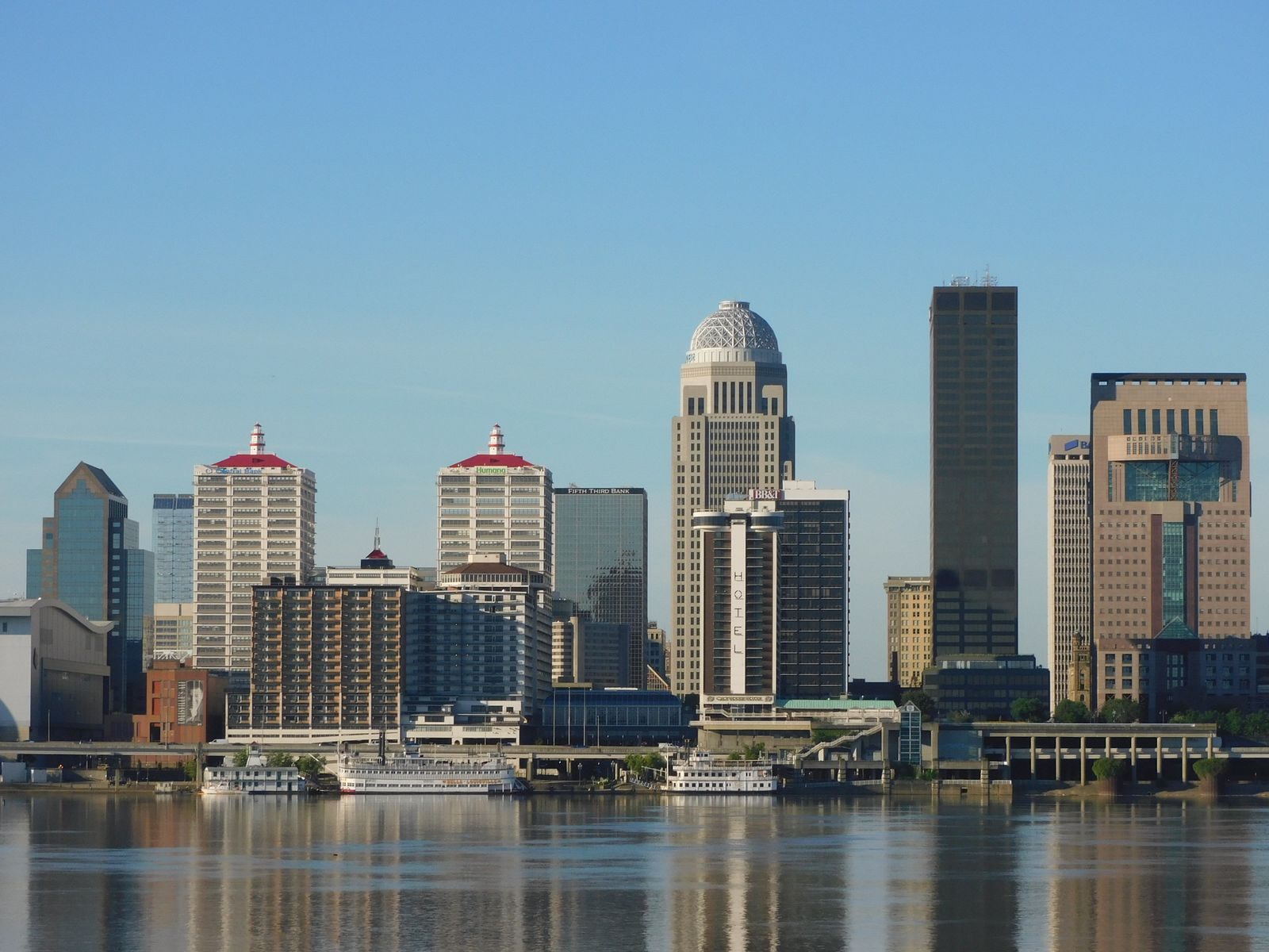 Louisville skyline reflected in the Ohio River, home port for a steamboat cruise in Louisville, KY